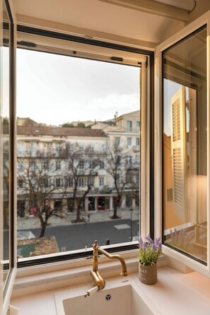 A window with a brass faucet and a small potted plant on the windowsill. - Porta Reale Suite by Corfuescapes (Kerkira)