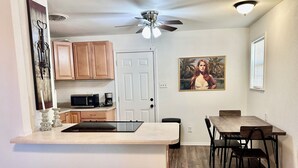 A compact kitchen with a microwave, coffee maker, and wooden cabinets.