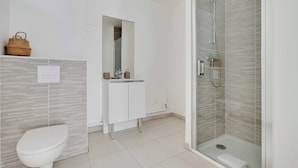 Ein modernes Badezimmer mit Toilette, Waschbecken und Dusche.