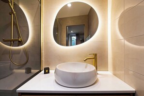 A bathroom with a round mirror, a white sink, and a gold showerhead. - Modern, A/C Apartment - 2bdr/4p - Cannes/beach (Cannes)