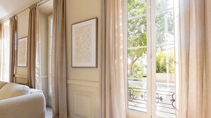 A room with a large window, a sofa, and framed artwork on the wall. - Modern, A/C Apartment - 2bdr/4p - Cannes/beach (Cannes)