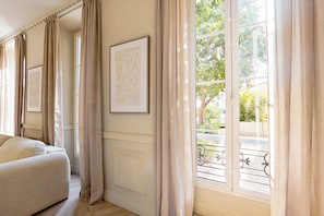 A room with a large window, a sofa, and framed artwork on the wall. - Modern, A/C Apartment - 2bdr/4p - Cannes/beach (Cannes)