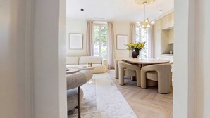 A modern living room with a sofa, a dining table with chairs, a chandelier, and a vase with flowers. - Modern, A/C Apartment - 2bdr/4p - Cannes/beach (Cannes)