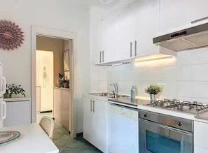 A modern kitchen with white cabinets, stainless steel appliances, and a visible dishwasher. - Roses House - One Bedroom Apartment, Sleeps 2 (Arenzano)