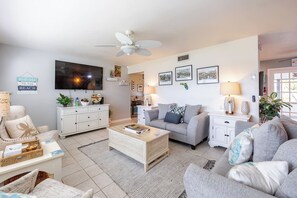 A living room with a television, sofa, coffee table, and decorative pillows. - Epic Relaxing Luxury Kings and Hot Tub Bungalow (Cape Coral)