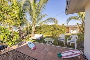 A patio area with two white chairs, a small table, and two surfboards. - Epic Relaxing Luxury Kings and Hot Tub Bungalow (Cape Coral)