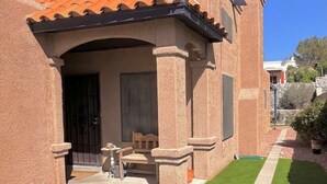 Una casa con techo de tejas, un porche cubierto y un césped bien cuidado.