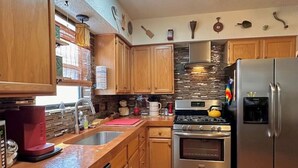 Una cocina con armarios de madera, un refrigerador de acero inoxidable, una estufa y un lavavajillas.