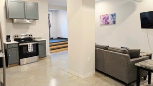 A modern kitchen with grey cabinets, a stainless steel stove, and a coffee maker. - Novel King Suite- Central West End near SLU 101 (St. Louis)