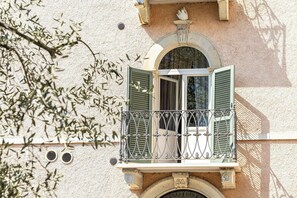 A building with a balcony, a window with shutters, and a decorative stone archway. - Stunning  villa for 4 people with pool, WIFI, A/C, TV, patio and panoramic view (Bargni)