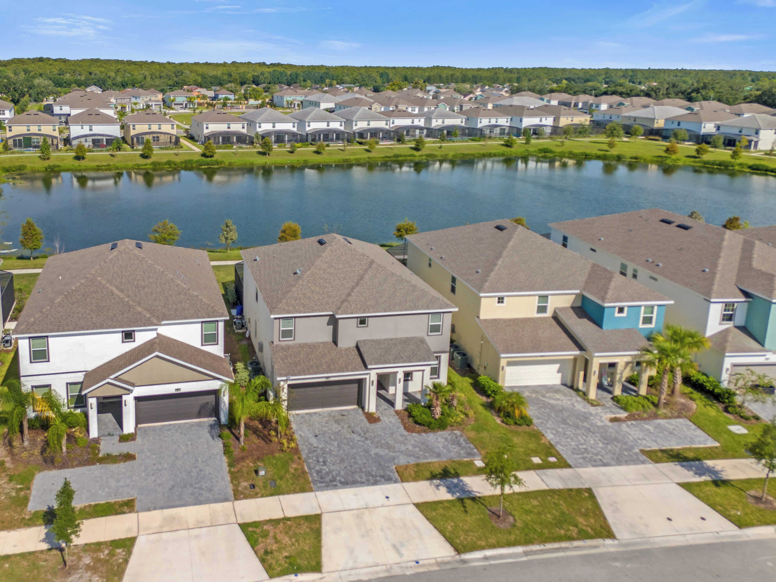 Un quartiere residenziale con case, un lago e cielo sereno.
