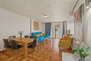 Ein modernes Wohnzimmer mit Essbereich, einer Sofagarnitur und einem Couchtisch.
