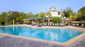 A swimming pool with lounge chairs and a covered area with a distinctive tower-like structure. - Comfy Cove  Resort Stay for 8 (Kissimmee)