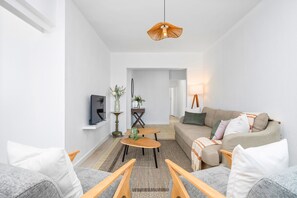 Ein modernes Wohnzimmer mit Sofa, Couchtisch und Fernseher.