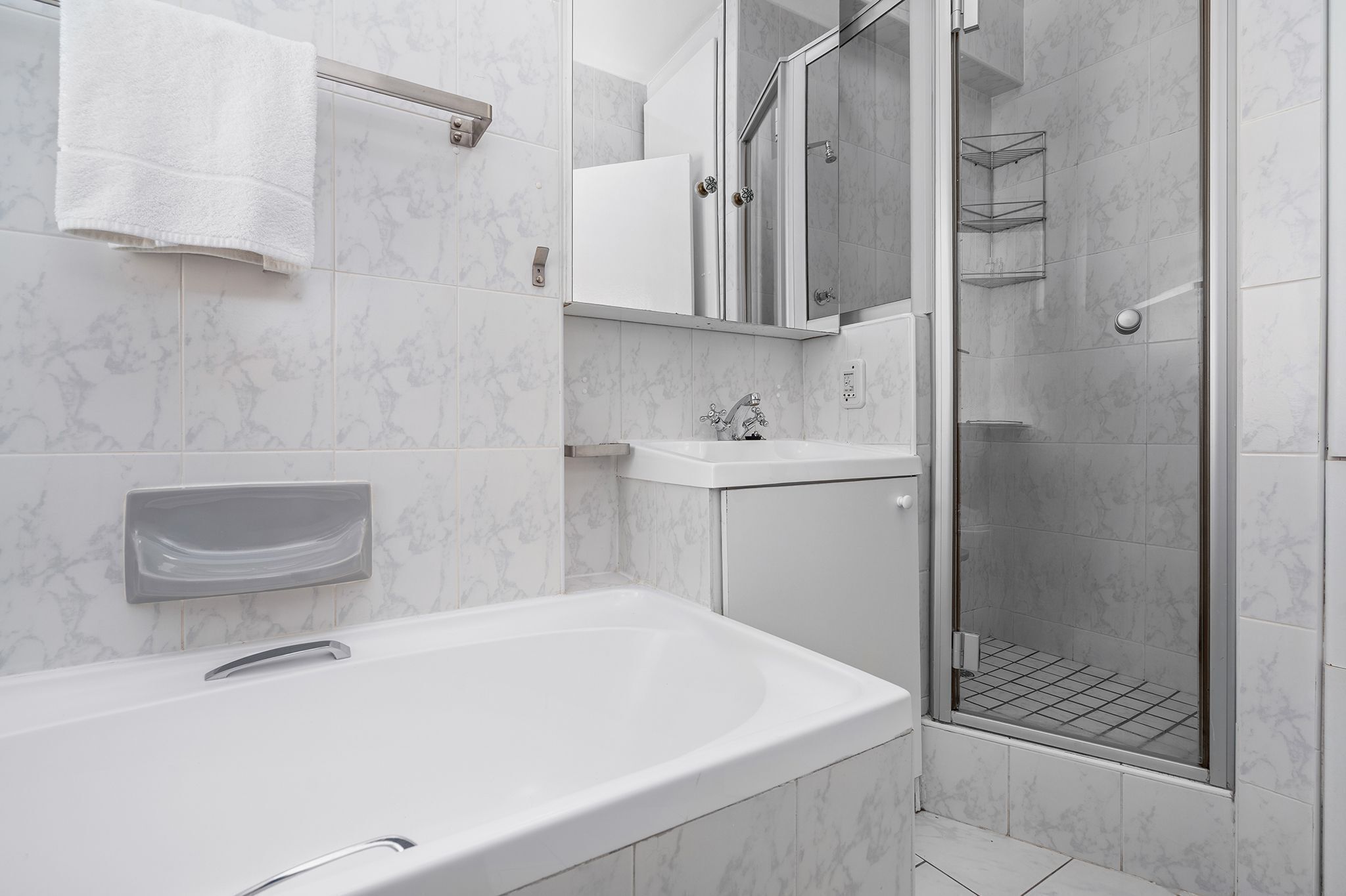 A modern bathroom with a bathtub, a shower, and a vanity.