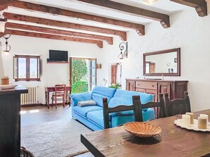 Ein Zimmer mit einem blauen Sofa, einem Holzesstisch und einem großen Spiegel.