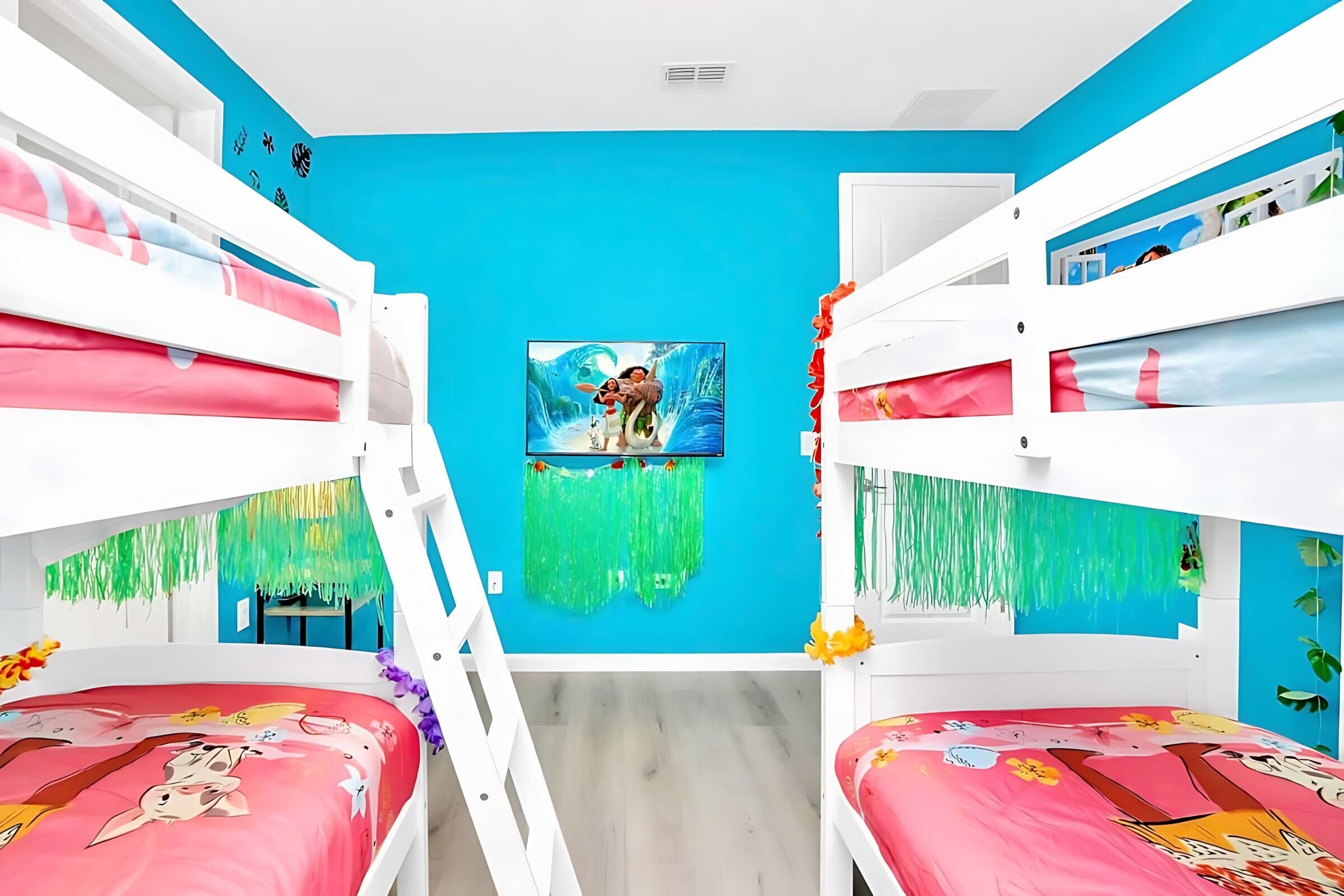 A children's room with bunk beds, a blue wall, and a picture of a cartoon character.