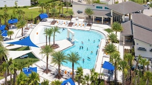 An aerial view of a resort with a large pool surrounded by palm trees and lounge chairs. - Upstay Family Resort Mansion- Pool, Games, Theater (Kissimmee)