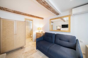 A room with a blue sofa, a wooden wardrobe, a mirror, and a lamp. - Modern Studio a/c 2P - Port de Saint-tropez (Saint-Tropez)