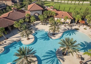An aerial view of a resort with a large swimming pool, palm trees, and resort buildings with red-tiled roofs. - Upstay-solterra Home With Private Pool & Hot Tub (Davenport)