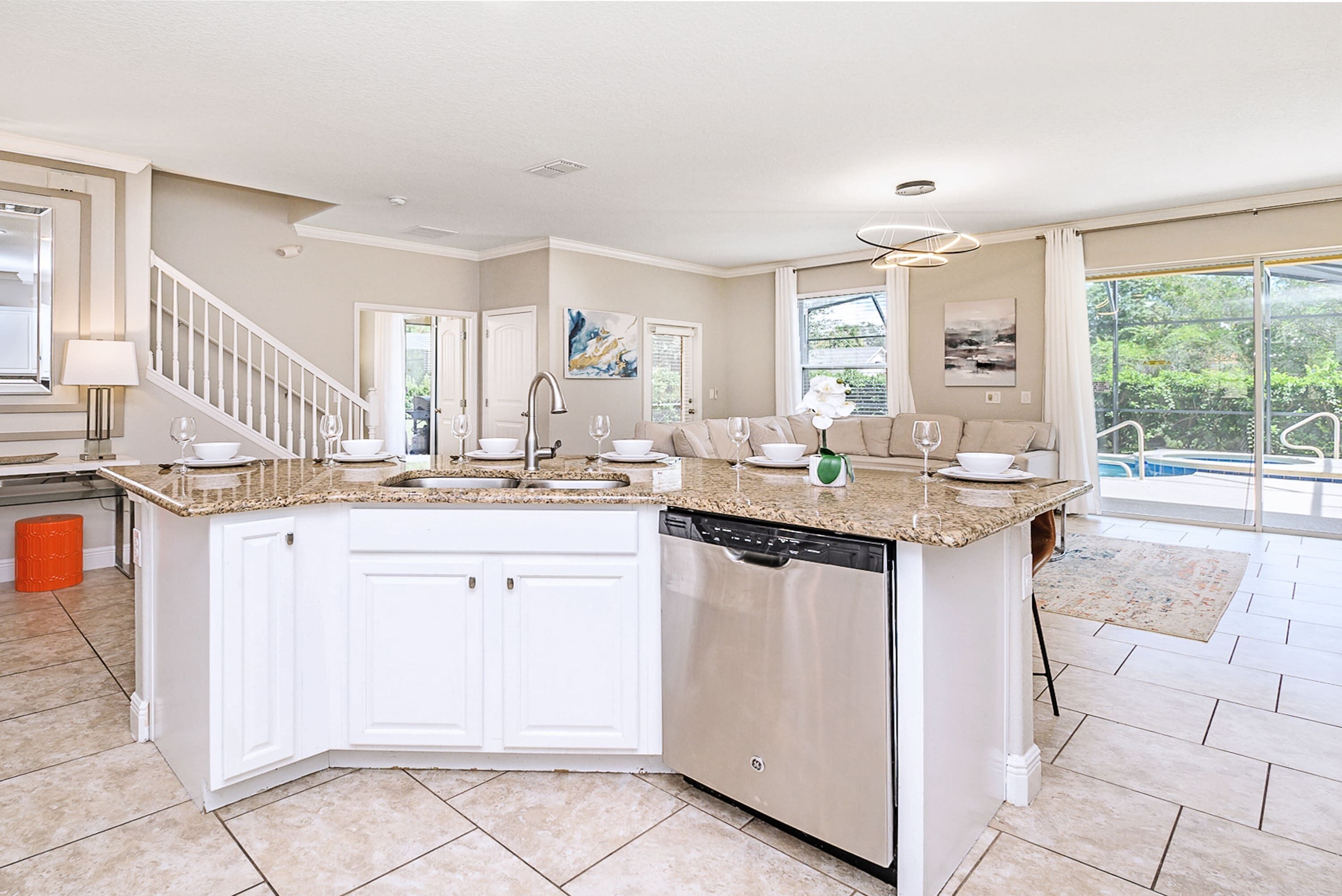A modern kitchen with white cabinets, a dishwasher, and a granite countertop.