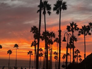 A sunset view with palm trees and street lamps. - Discover this beach close 2-bedroom apartment in downtown San Clemente! (San Clemente)