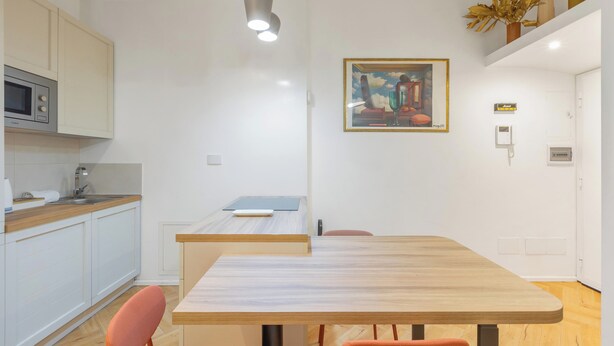 A modern kitchen with a microwave, a sink, and a wooden countertop. - Casa Crilù by BarbarHouse (Roma)