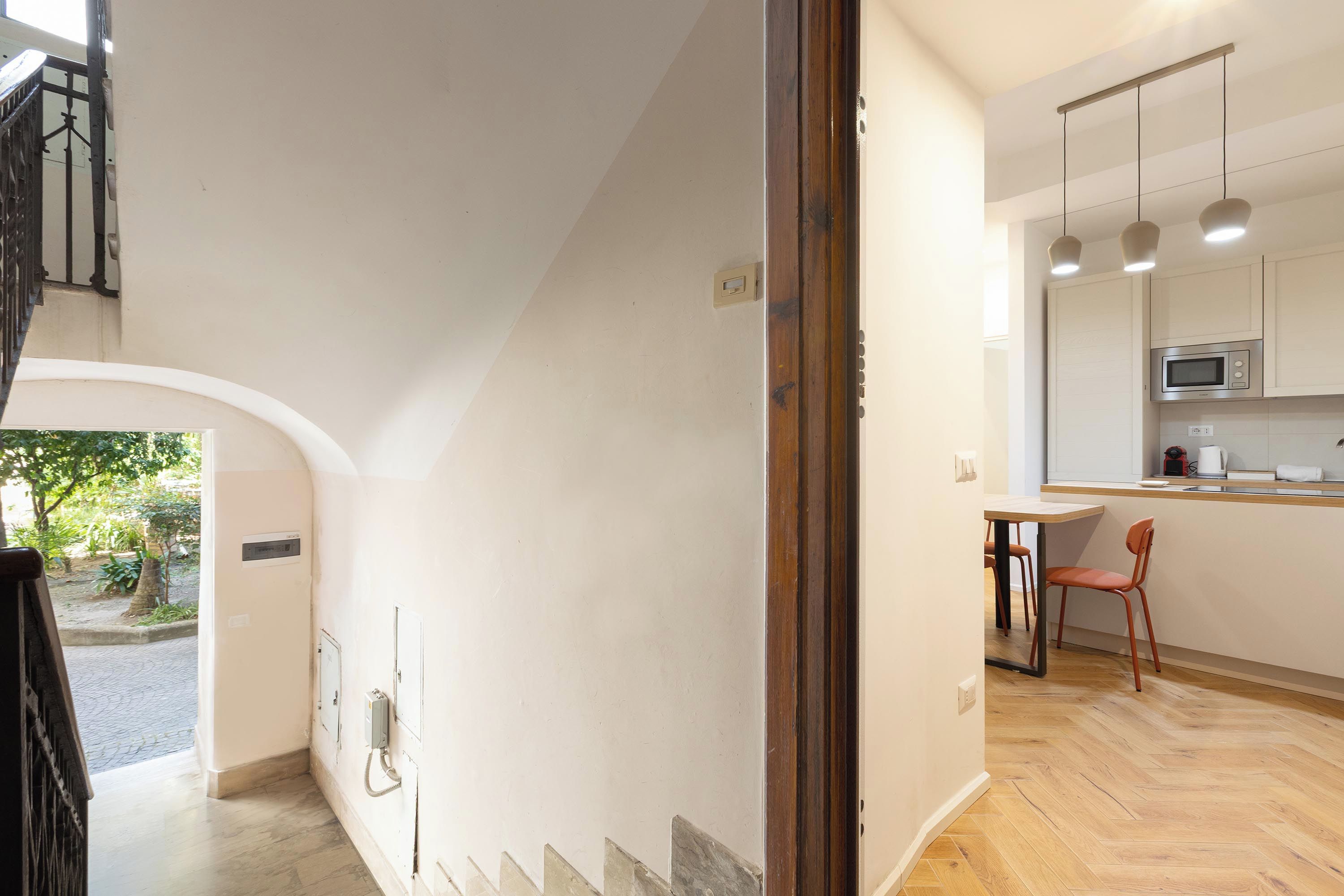 Eine moderne Küche mit Essbereich, Holzboden und einer Treppe zu einer oberen Ebene.