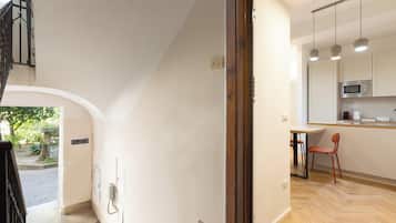 Eine moderne Küche mit Essbereich, Holzboden und einer Treppe zu einer oberen Ebene.