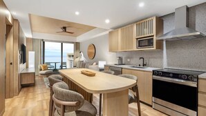 A modern kitchen with a central island, built-in microwave, stainless steel oven, and wooden cabinetry. - Waikiki | Romantic Island Retreat | Pool + Spa (Honolulu)