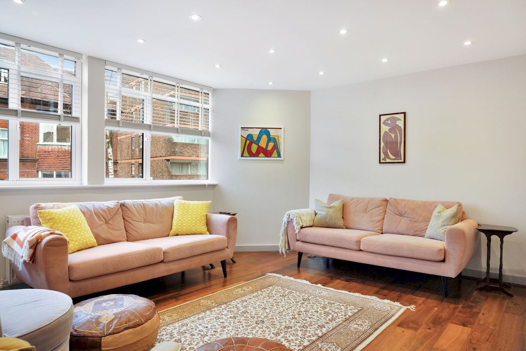 A living room with two sofas, a patterned rug, and artwork on the walls.