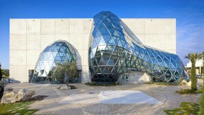 A modern building with a unique glass facade and a large arched entrance. - Beachfront Getaway with Resort-Style Pool (Madeira Beach)