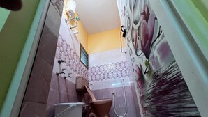 Un baño con inodoro, bidé y ducha.