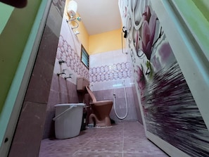 A bathroom with a toilet, bidet, and shower. - Rivera Inn (Tiruchirappalli)