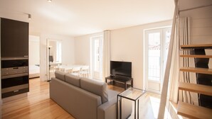 Ett modernt vardagsrum med en soffa, en tv och en matplats.