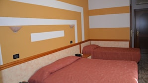 A hotel room with two beds, a wooden headboard, a wall-mounted light fixture, and a door. - La Formica (Savignano sul Panaro)