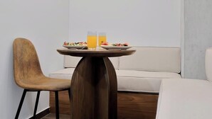 Ein kleiner Essbereich mit einem runden Tisch, zwei Stühlen und einer Couch.