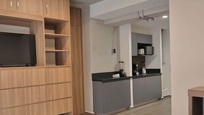 Een moderne keuken met grijze kastjes, een zwart aanrechtblad en een inbouwoven.