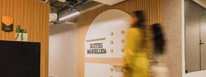 Ein Empfangsbereich mit einem Schild, das 'SUTTES MARSELLESA' zeigt, und einem Holzpaneel-Design.