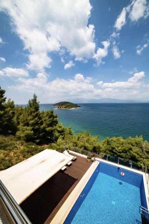 Ein Pool mit freiem Blick auf das Meer und eine entfernte Insel.