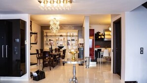 A modern living room with a chandelier, a dining area, and a kitchen in the background. - Elegant Nian Villa Sea - Luxury Stay in Drosia, Chalkida (Chalkida)