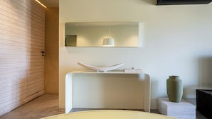 Een moderne badkamer met een wit wastafelmeubel, een spiegel en een hangende lamp.