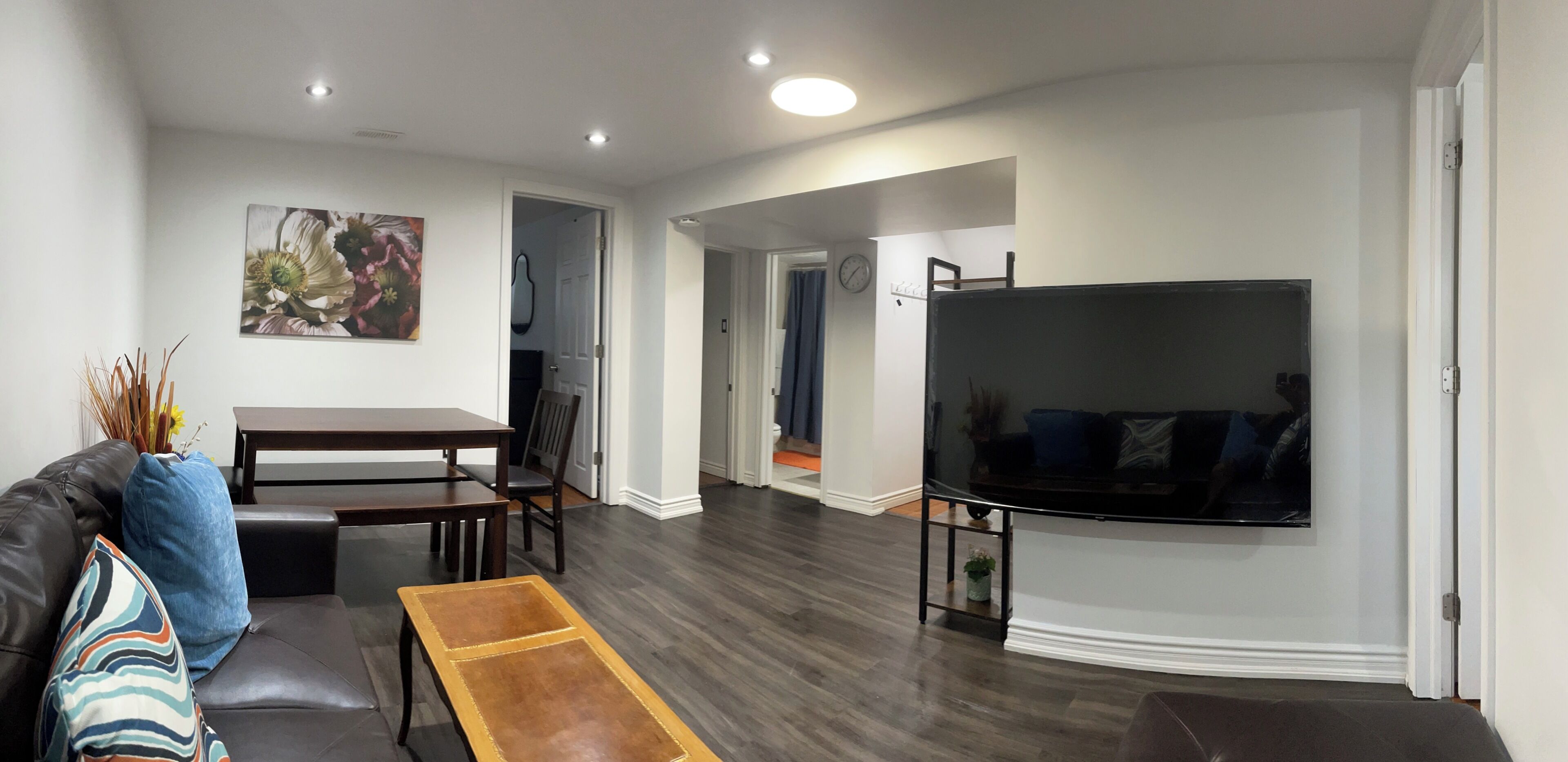 Un salon comprenant un canapé, une table basse, un téléviseur et un coin repas avec des chaises et une table.