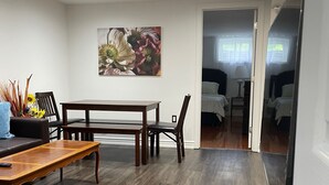 Un salon moderne avec une table à manger, des chaises, un canapé et un tableau au mur.