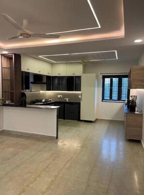 Una cocina moderna con una isla central, iluminación empotrada y un ventilador de techo.