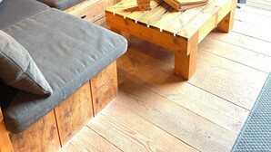 Interior acogedor de una cabaña con un sofá, almohadas y una mesa de centro de madera.