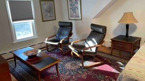 A room with two leather chairs, a small table with a bowl, a lamp, and a patterned rug. - Immaculate 3 bedrooms and very private backyard with firepit. (Bloomfield)