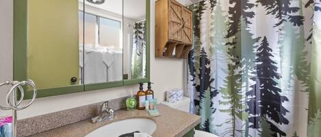 A bathroom with a sink, mirror, and toilet.