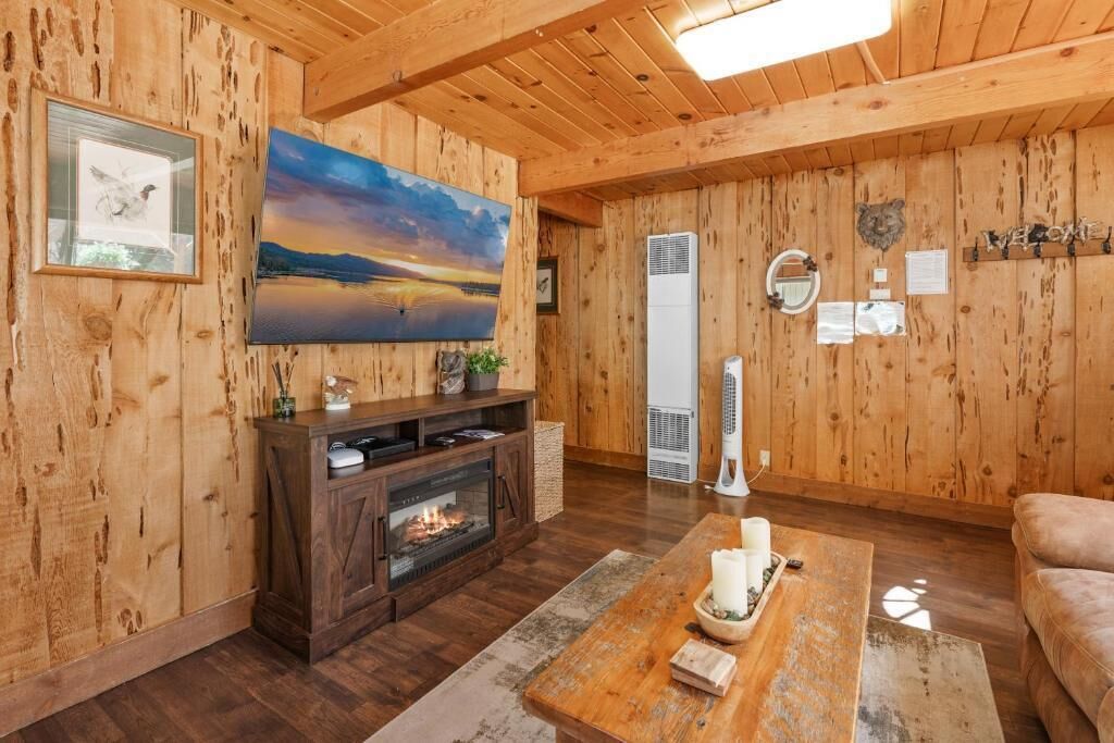 A wooden interior with a fireplace, a large painting, and a cozy seating area.