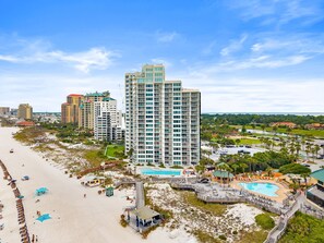 A high-rise hotel with multiple floors, a pool area, and a beachside location. - Stunning Gulf View and Beach Front Coastal Escape (Miramar Beach)